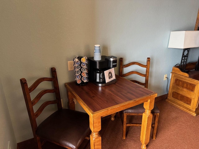 dining space featuring dark carpet