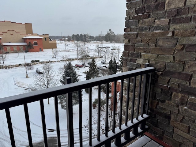 view of snow covered back of property