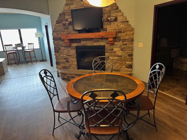 dining space with hardwood / wood-style floors and a fireplace