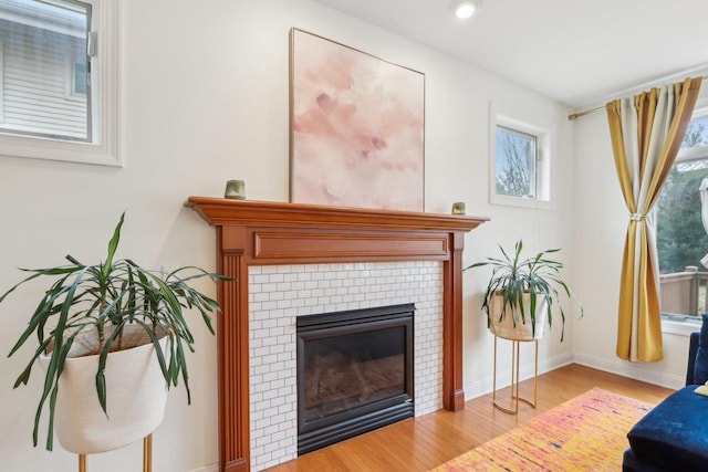 sitting room with a tiled fireplace and light hardwood / wood-style floors