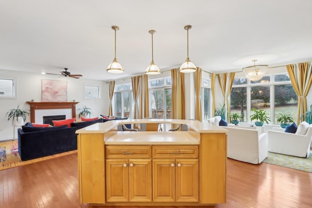 kitchen with pendant lighting, a center island with sink, and light hardwood / wood-style flooring