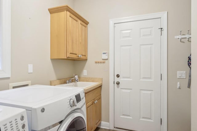 laundry room with cabinets, washing machine and clothes dryer, and sink