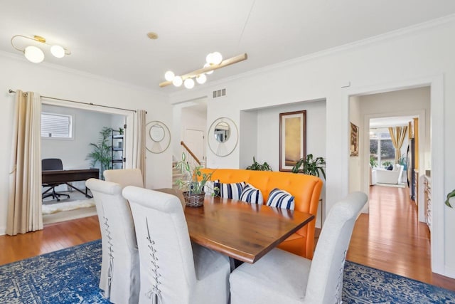 dining area with crown molding and hardwood / wood-style flooring