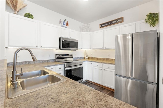 kitchen featuring white cabinetry, sink, dark wood-type flooring, and appliances with stainless steel finishes