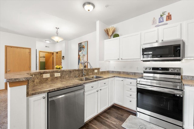 kitchen with stainless steel appliances, sink, white cabinets, and kitchen peninsula