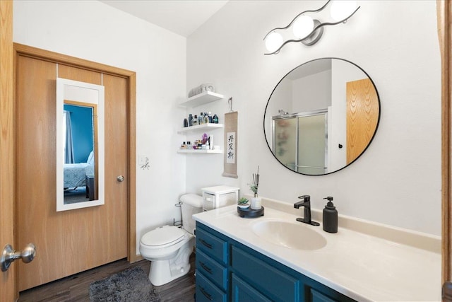 bathroom featuring vanity, toilet, an enclosed shower, and hardwood / wood-style floors