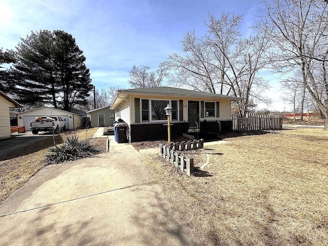 bungalow-style house with a garage, an outbuilding, brick siding, and covered porch