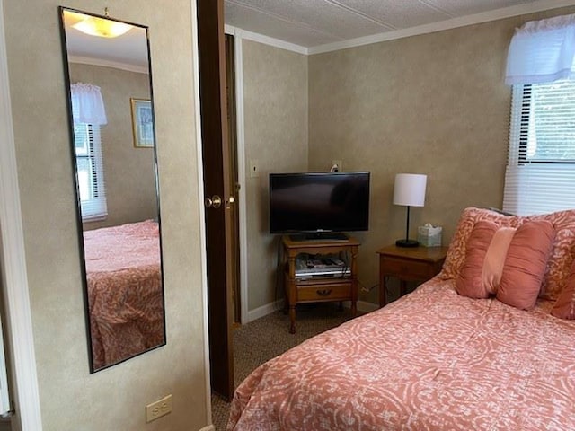 bedroom with ornamental molding and carpet flooring