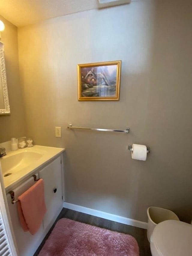 bathroom featuring hardwood / wood-style flooring, vanity, and toilet