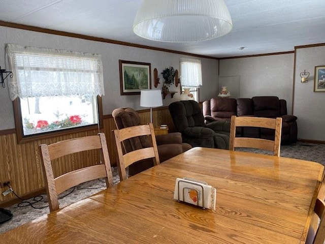 dining space featuring crown molding and wood walls