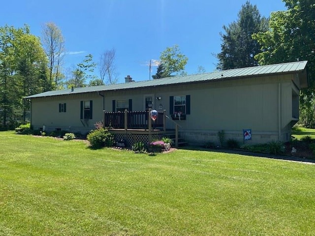 back of property with a wooden deck and a lawn