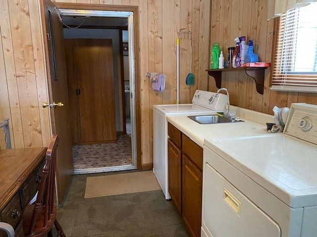 laundry area featuring cabinets, washer and dryer, and wood walls