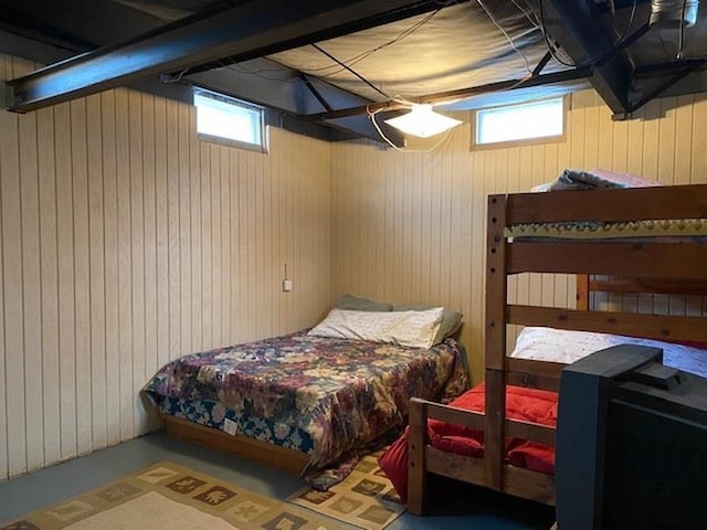 bedroom featuring wooden walls