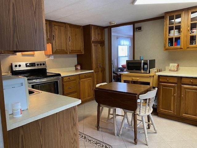 kitchen featuring stainless steel appliances and light tile patterned flooring