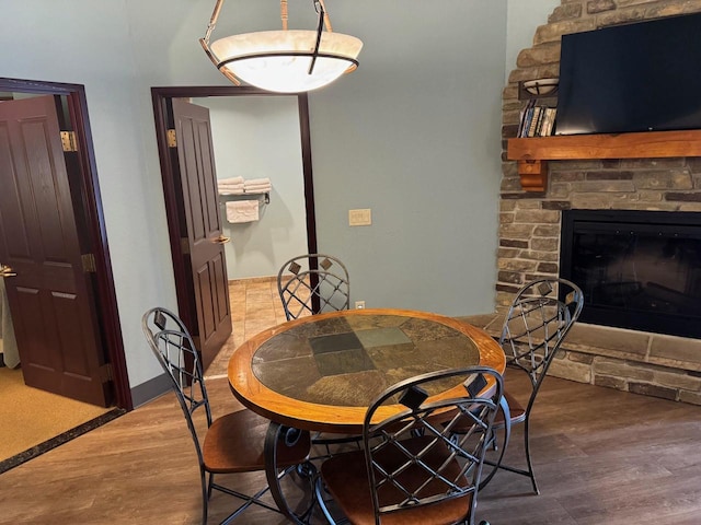 dining room with hardwood / wood-style flooring and a fireplace