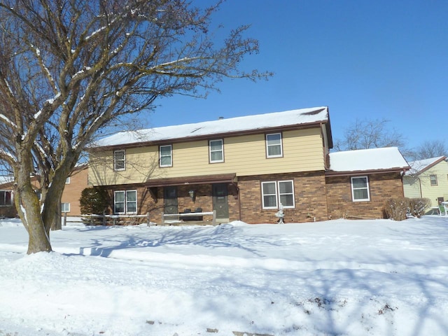 view of snow covered back of property