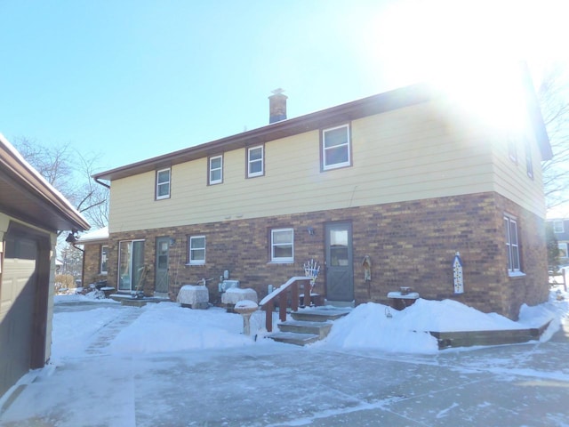 view of snow covered rear of property