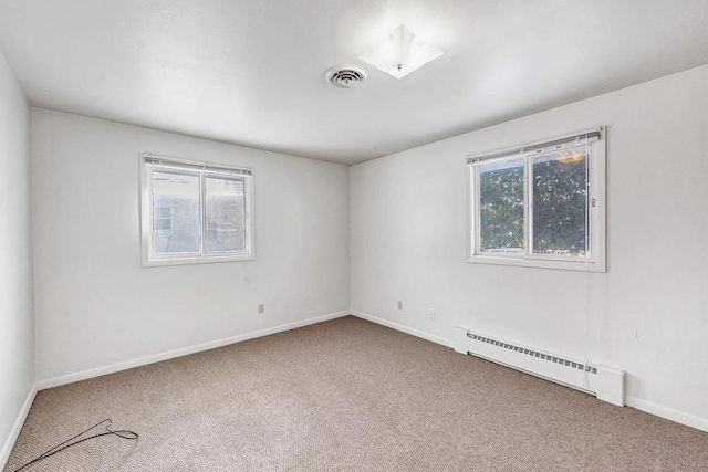 carpeted empty room with a healthy amount of sunlight and a baseboard heating unit