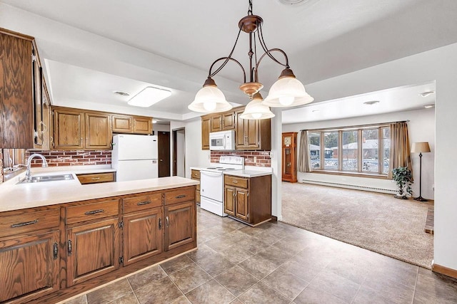 kitchen featuring sink, baseboard heating, dark carpet, pendant lighting, and white appliances