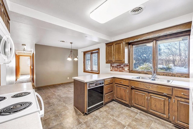 kitchen with pendant lighting, white range with electric stovetop, sink, black dishwasher, and kitchen peninsula