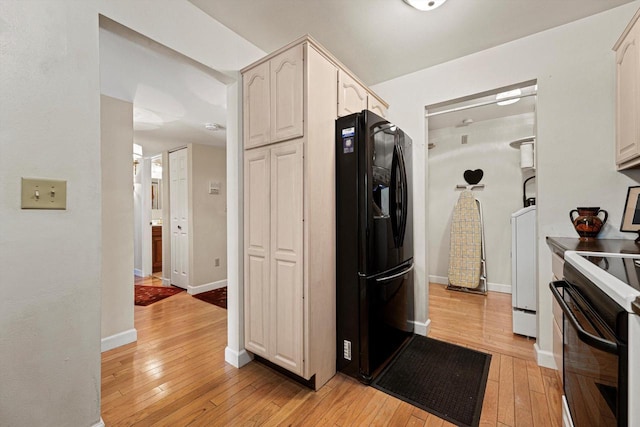 kitchen featuring white cabinetry, electric range, black fridge with ice dispenser, and light hardwood / wood-style floors