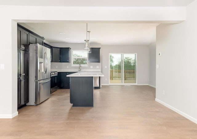 6542 Prairie Wood Dr, Mcfarland, WI 53558 - kitchen with stainless steel appliances, a sink, light countertops, light wood-style floors, and a center island