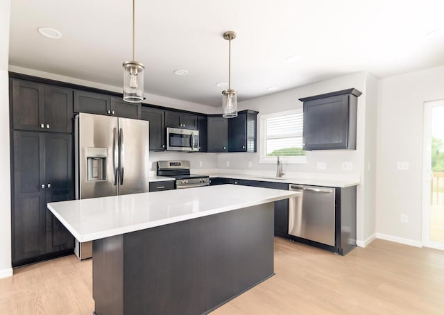 6542 Prairie Wood Dr, Mcfarland, WI 53558 - kitchen with appliances with stainless steel finishes, a sink, light wood-type flooring, a center island, and recessed lighting