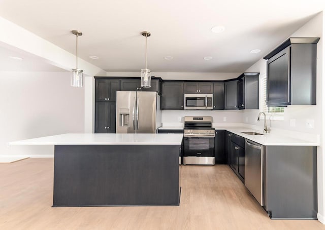6542 Prairie Wood Dr, Mcfarland, WI 53558 - kitchen with stainless steel appliances, a sink, light wood finished floors, a kitchen island, and light countertops