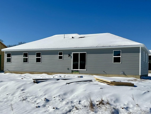 view of snow covered back of property