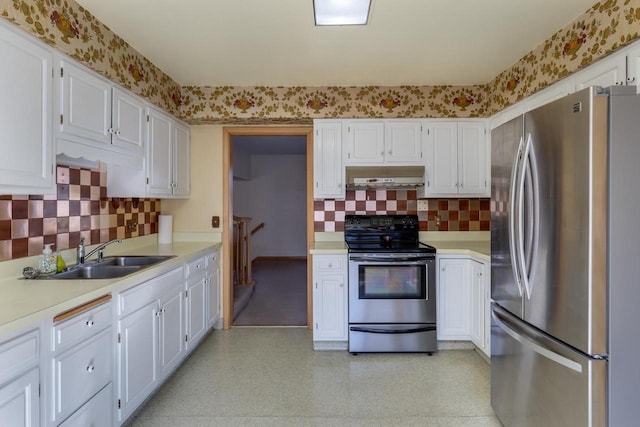 kitchen with light countertops, appliances with stainless steel finishes, a sink, under cabinet range hood, and wallpapered walls