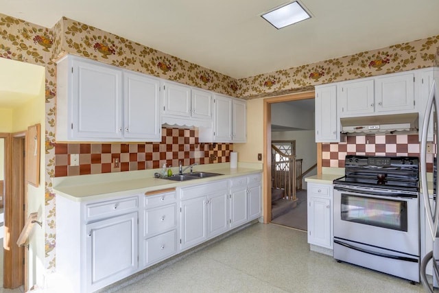 kitchen featuring light floors, wallpapered walls, a sink, stainless steel range with electric stovetop, and extractor fan