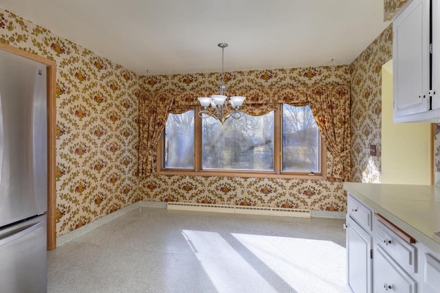 unfurnished dining area with a baseboard heating unit, a notable chandelier, and wallpapered walls