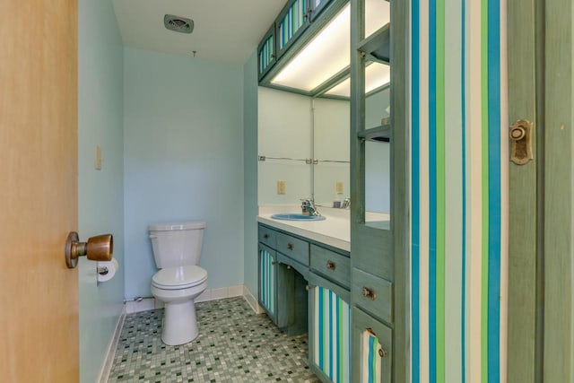 bathroom featuring visible vents, toilet, vanity, tile patterned flooring, and baseboards