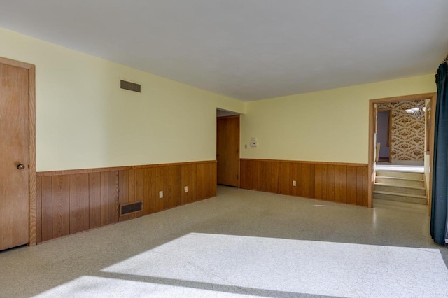 spare room with stairs, wainscoting, and visible vents