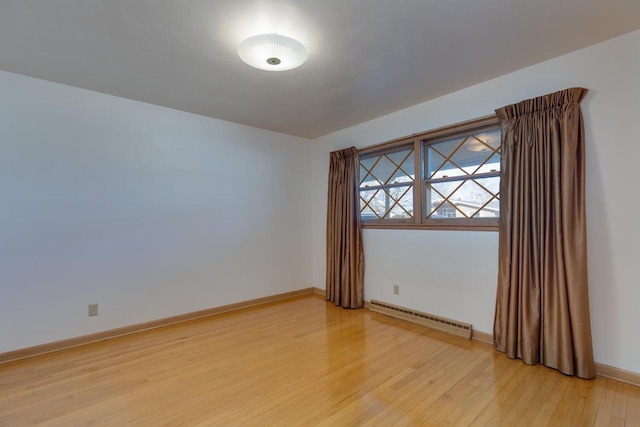 unfurnished room with light wood-style flooring, baseboards, and baseboard heating