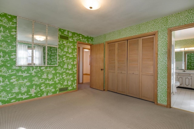 unfurnished bedroom with carpet, visible vents, and wallpapered walls