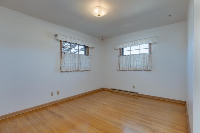 empty room featuring visible vents, plenty of natural light, light wood-style flooring, and baseboards