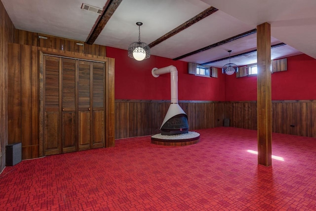 interior space featuring a wainscoted wall, wooden walls, and beamed ceiling