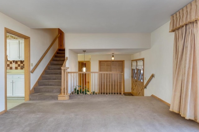 carpeted spare room featuring baseboards