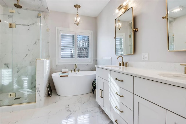 bathroom featuring a chandelier, vanity, and independent shower and bath