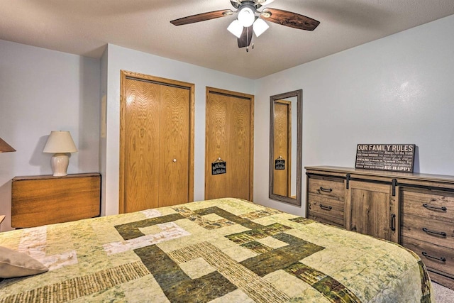 bedroom with ceiling fan and multiple closets