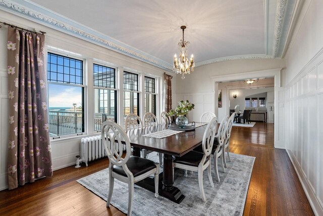 dining space with a chandelier, dark hardwood / wood-style flooring, and radiator