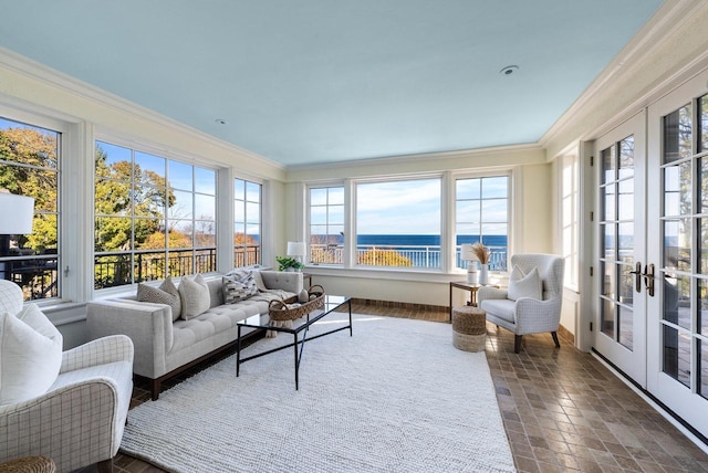 sunroom with a water view and french doors