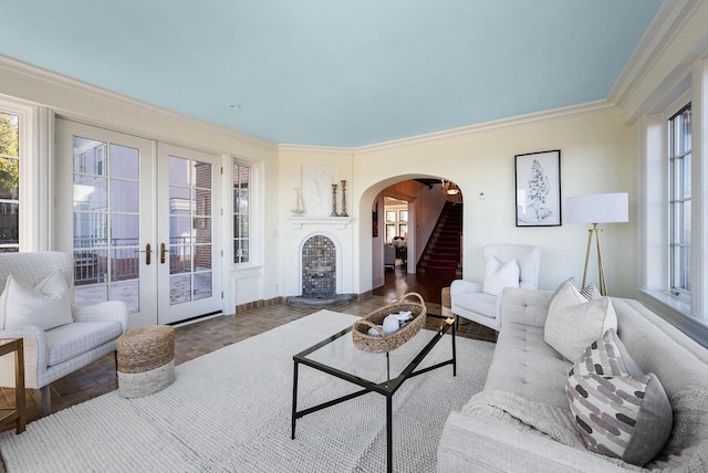 living room featuring french doors, ornamental molding, and a wealth of natural light