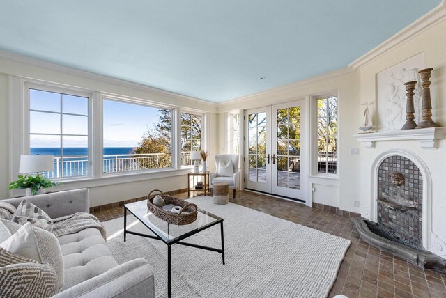 living room with ornamental molding, a water view, and french doors