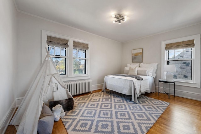 bedroom featuring ornamental molding, radiator, and hardwood / wood-style floors