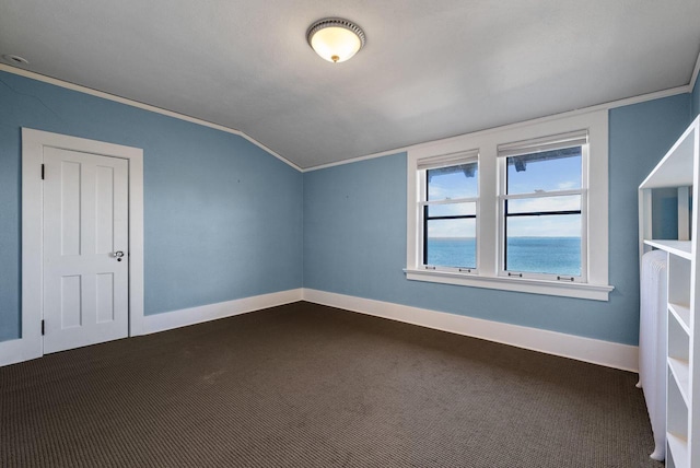 additional living space with dark carpet, vaulted ceiling, and a water view