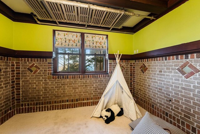 rec room with brick wall and carpet floors