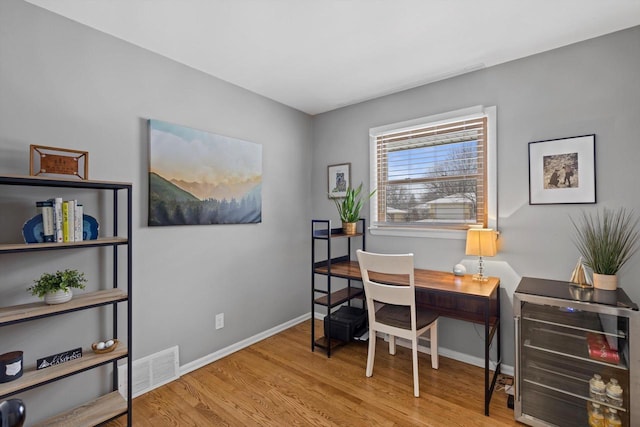 home office featuring wine cooler and light hardwood / wood-style floors