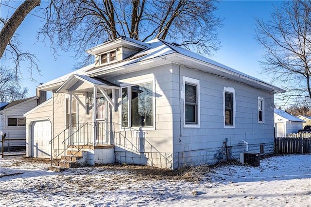 view of front of home featuring cooling unit and a garage